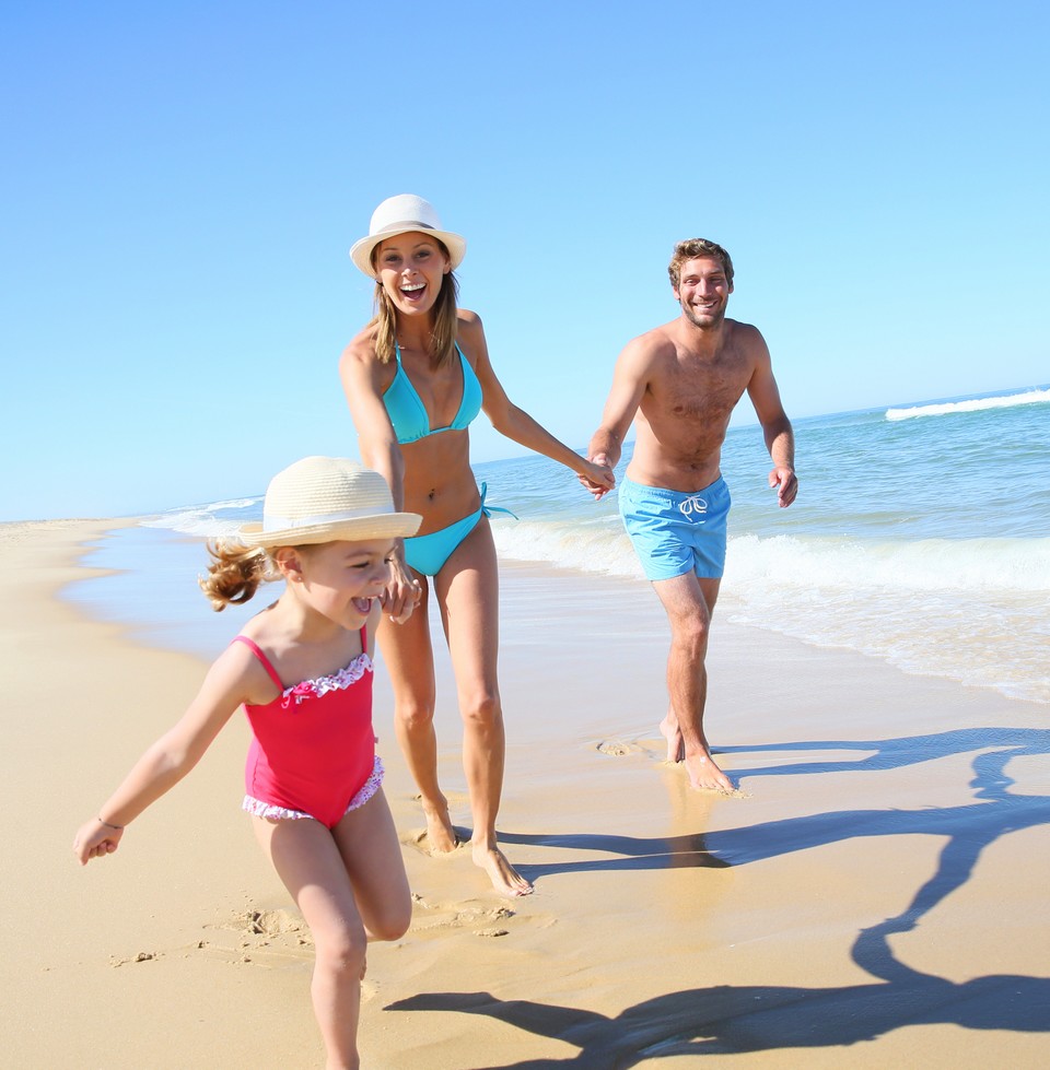 Glückliche Familie läuft am Strand, Sommerurlaub, Pauschalreise, Urlaub buchen